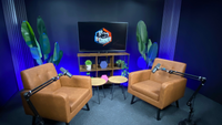 Professional podcast studio setup in Sofia with two armchairs, studio microphones, LED background lighting, and TV screen for video podcast recording and interview production